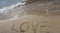 Inscription Love drawn on the sand. Concept of true and honest romantic feelings. spa novel on the sea