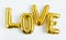 Inscription LOVE foil inflatable golden ballon on the white background. Love, romance and Valentines day concept. Flat lay