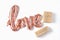 The inscription love in the form of a balloon in pink gold color on a white background. gift boxes of various sizes in craft paper