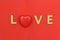 The inscription Love on a red background in wooden letters with a heart in the middle.Greeting card or banner. Happy valentine`s