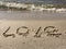 The inscription Love on the sandy shore. Sign drawn on the sand, closeup.