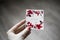 The inscription `With love` on a white background with flowers, a hand with the signed paper. wooden background