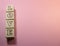 The inscription LOVE on wooden cubes. On a pink background, the inscription love.