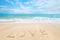Inscription Love written on the sandy beach with ocean wave