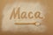Inscription Maca of Maca gelatinized flour on beige background. Peruvian superfood, natural organic supplement.  Wooden spoon with