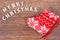 Inscription Merry Christmas with festive red sock on rustic board