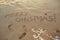 The inscription Merry Christmas on the sand on the beach.