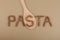 Inscription PASTA lined of uncooked fusilli. Wooden spoon. Design element. Gluten free flax pasta. Uncooked Fusilli made of