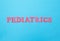Inscription pediatrics in red letters on a blue background. Concept medical section dealing with the treatment of