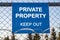 The inscription `PRIVATE PROPERTY keep out` on a blue plate