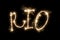 The inscription Rio on a black background with sparklers using a simulated long exposure