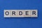 Inscription of a short gray word order in small square wooden letters