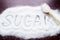 Inscription sugar made into pile of white granulated sugar