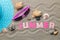 Inscription summer from paper of multi-colored letters and seashells and summer accessories on the sea sand. Summer. relaxation. v