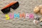 Inscription summer from paper of multi-colored letters and seashells and summer accessories on the sea sand. Summer. relaxation. v