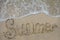 Inscription summer on a sandy beach and sea wave