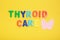 inscription thyroid care and thyroid gland from pink felt on a yellow background nutrition for thyroid diseases