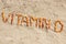 Inscription vitamin D on sand at beach, summer time and healthy lifestyle