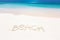 Inscription word BEACH on perfect tropical sandy beach
