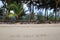 An inscription â€˜Happy New Yearâ€™ on the sandy beach on the background of palm trees.