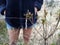 Insect caught in web in bush or plant with woman in background