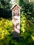 Insect hotel, wooden house in green garden giving protection and nesting aid to bees and insects