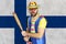 An insecure clown holds a bat in his hands against the background of the flag of Finland