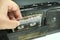 Insert an audio cassette into a tape recorder