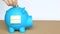 Insert coins in blue piggy bank with sticky note and retirement word on concept of saving money for retirement