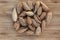 Inshell almonds in a heap in the center on a brown wooden background