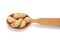 Inshell peanuts lies in a wooden spoon, tasty fruit is isolated on a white background