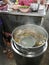 Inside an Asian-style noodle shop, a stainless steel pot is boiling the broth.