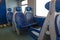 Inside the cab of the modern Express. Nobody in blue chairs by the window. Fuzziness. Comfortable chairs and table in the