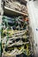 Inside cabinet with switchboard and other telecommunication mobile network hardware equipment with many cables