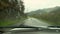 Inside of a car, driver place point of view, driving country road at rainy weather day, water drops. Rain drops on a