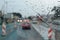 Inside car when rainning, Road view wtih restriction signs through car window with rain drops. Drizzle on the windshield