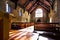 Inside of a church with wooden benches and floor