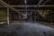 Inside dark abandoned ruined wooden decaying hangar with rotting columns