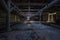 Inside dark abandoned ruined wooden decaying hangar with rotting columns