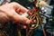 Inside details of the old personal computer. Cooler, motherboard, wires and video card in the dust. Man is holding cables in his