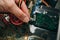 Inside details of the old personal computer. Cooler, motherboard, wires and video card in the dust. Man is holding hard disk drive