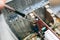 Inside details of the old personal computer. Wires and video card in the dust. Man is cleaning motherboard with a brush. Broken PC