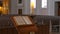 Inside an empty catholic church. Wooden pews for church members and the priest`s prayer book.