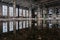 Inside of flooded dirty abandoned ruined industrial building with water reflection