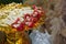 inside left, white and red garland is placed on a golden pedestal on blur background, nature, object, worship, buddha, copy space