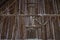 Inside of an old barn with beams and vertical boards and snow