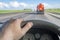 An inside view of a car driving behind a flammable fuel truck