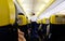 Inside view of Ryanair flight. Cabine view of the plane with flagship yellow and blue seats. Passengers are seated while