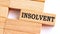 INSOLVENT word written on wood block. INSOLVENT text on table, concept.Business photo text make something more modern or up to