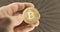 Inspecting Physical bitcoin held in hands closeup
